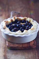 Bilberry Quiche in a Ceramic Dish on rustic wooden background.