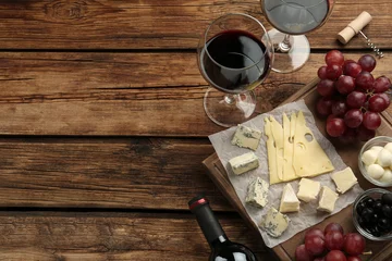 Gordijnen Tasty red wine and snacks on wooden table, flat lay. Space for text © New Africa