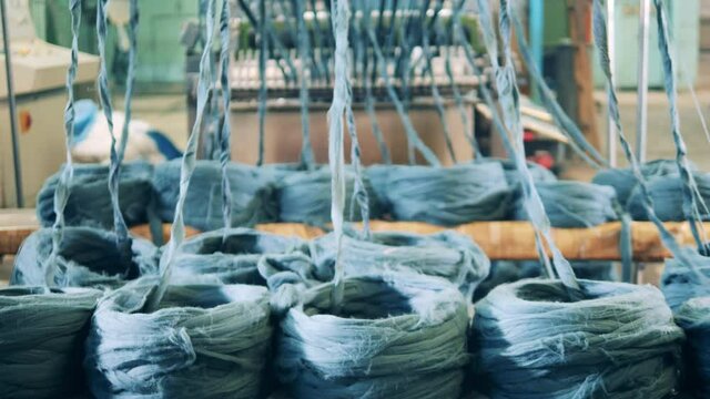 Hasps of blue yarn are getting unwound