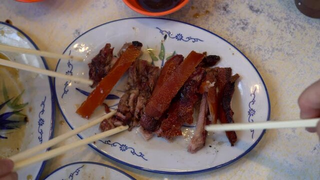 Eating suckling pig bbq pork plate in Hong Kong restaurant Chinese delicacy in small serve