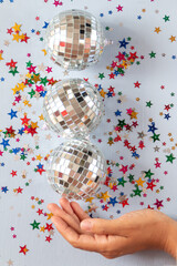 Disco ball on blue background with multicolored stars confetti 
