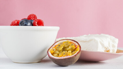 A bowl full of fresh fruit: blueberries, raspberries and passion fruit. Cottage cheese. Fresh breakfast items. Healthy eating, healthy lifestyle.