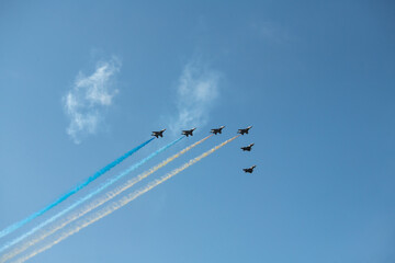 Group of aircrafts  flying with color smoke in blue sky under the Kiev during the parade on the...