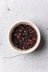 selective focus, natural black leaf tea. brewing in a clay bowl. vertical angle, macro. on a light background. for menus and cafes