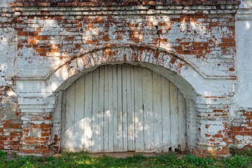 Ancient Russian wooden gate arch in a brick wall of the Kremlin in Vladimir city