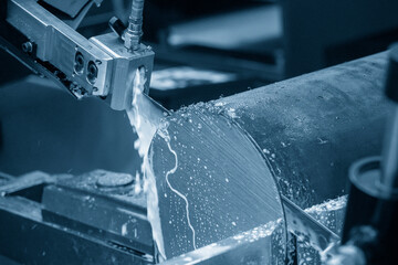 The automatic band saw machine cutting the metal bar with water base coolant method.