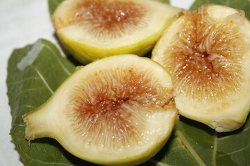 figs cut in half with leaf isolated on a white table, photo of Italian fig fruit.