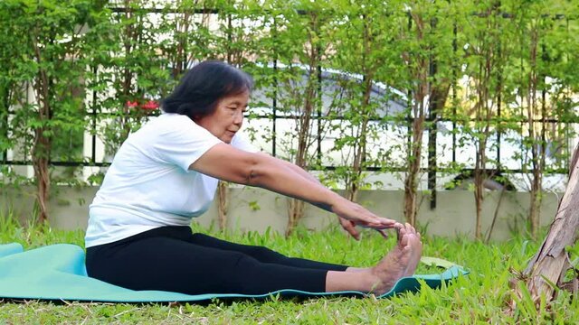 Asian elderly woman exercising at home to be healthy and help reduce the stress of social distancing During the coronavirus epidemic. senior health care concept
