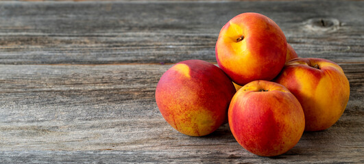 Vivid peaches and nectarines on wood background. Copy space