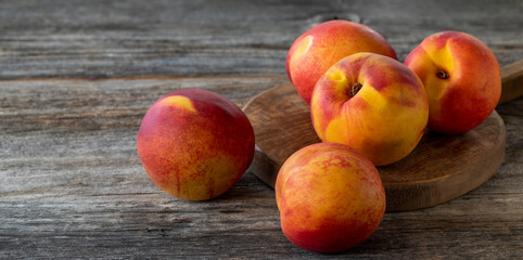 Fototapeta na wymiar Vivid peaches and nectarines on wood background. Copy space