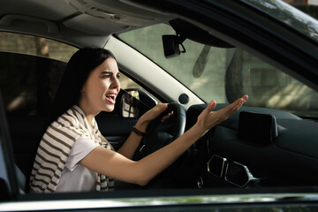 Plakat Stressed young woman driver's seat of modern car