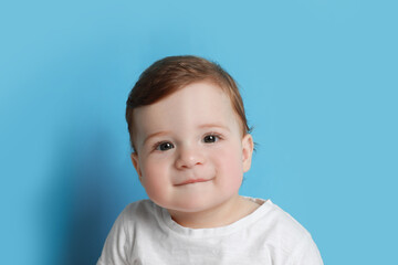 Cute little baby boy on light blue background