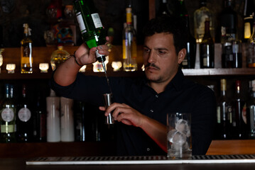 cocktail man pouring drink into shaker
