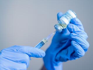 Focus on syringe, close up of doctor or nurse hands taking covid vaccination booster shot or 3rd...