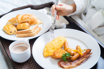 Close up woman enjoy breakfast on a bed in bedroom