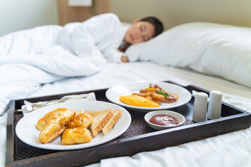 Breakfast in bed. Woman sleeping on the bed wake up late