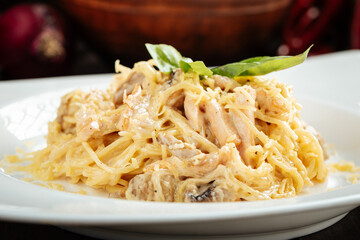 Carbonara paste with smoked chicken and mushrooms on wooden background