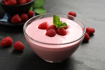 Delicious raspberry mousse with mint on black table