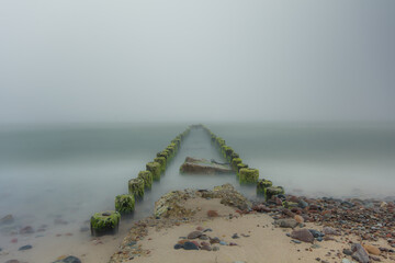 Falochrony znikające we mgle na Morzu Bałtyckim w miejscowości Wicie