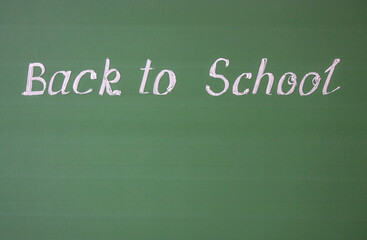 Obraz premium Handwritten inscription: back to school and copy space on a green chalkboard with chalk streaks