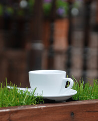 White cup with a hot drink on the background of a cozy restaurant.	