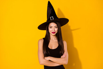 Photo of pretty witch lady crossed arms wear black dress cap isolated on yellow color background