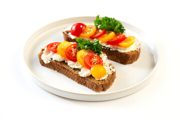 Two sandwiches with soft cheese and tomatoes