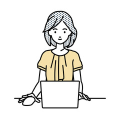 デスクで座ってPCを使っているオフィスカジュアルの女性