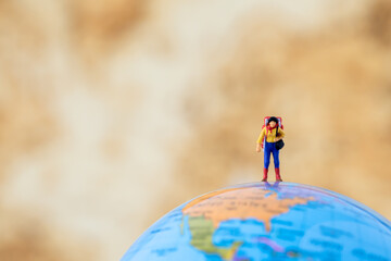 Miniature people Group of young tourist traveler traveling standing on Global world map travel around the world, business trip traveler adviser agency or online world wide marketing new transportation