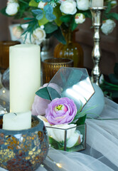 transparent box with a lilac rose. Candles on the table. An example of a romantic table setting.