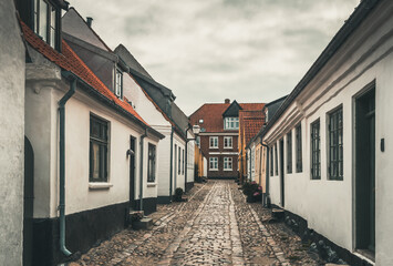 Ribe, Denmark - August 4, 2021: A small cobblestone street in Denmark's oldest city Ribe