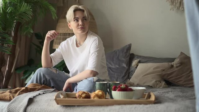 Lesbian couple happy lifestyle. Spbd Young Asian woman carries tray with breakfast to make surprise for girlfriend in light bedroom at home