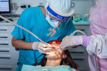 Process of removing dental braces from a Caucasian girl in a dental clinic with a female dentist