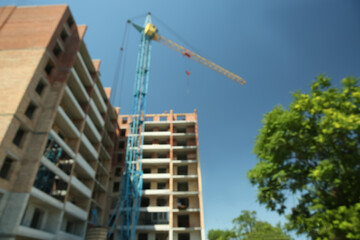 View of unfinished building and tower crane against blue sky