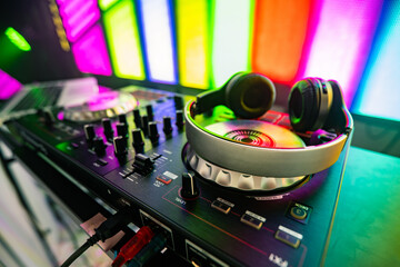 DJ console for mixing music and headphones. DJ controller close up on a colorful background