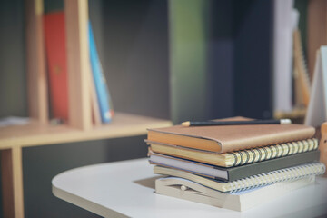 Diary and Planner Book on School table for Student, study for exam. Wooden desk with notebook against bookshelf in library. Desk for student work at home concept.