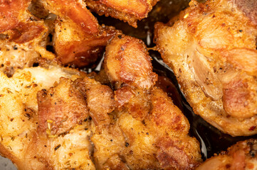 Fried pieces of meat in a frying pan, close-up, selective focus.