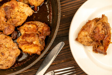 Fried pieces of meat in a frying pan, close-up, selective focus.