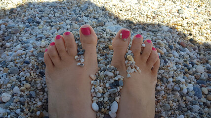 Tranquility concept: feet between the sand on the beach during a relaxing time