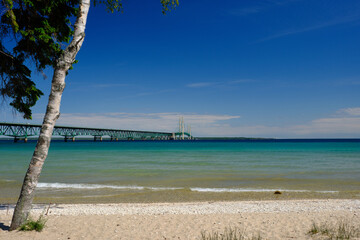 Obraz na płótnie Canvas The colorful and clear waters of the straits of Mackinac and the Mackinac Bridge connecting the Upper and Lower Peninsula of Michigan