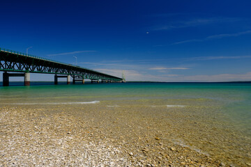 The colorful and clear waters of the straits of Mackinac and the Mackinac Bridge connecting the Upper and Lower Peninsula of Michigan