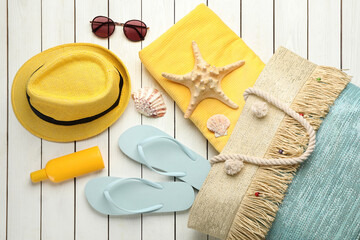 Fototapeta na wymiar Stylish bag and beach accessories on white wooden background, flat lay