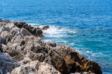 Fototapeta na wymiar Big rocks on the rough blue sea, concept of vacation and freedom 