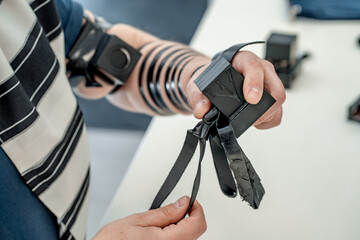 Religious jew, dressed in tallit and with a tefillin on his left hand, holds a tefillin for his...