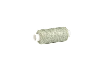 The needle is inserted into a spool of Beryl Green thread. The thread passes through the eye of the needle.