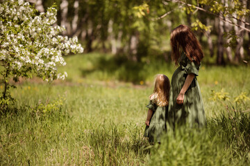 a girl with tall swamp flowers a pregnant woman with a daughter waiting for her second child