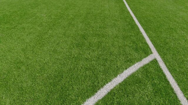 Soccer ball fly over white line of outdoor football soccer training field stadium