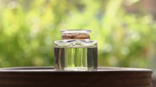 A drop of aromatherapy essential oil falling into a bottle