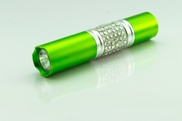 green pocket flashlight with white background