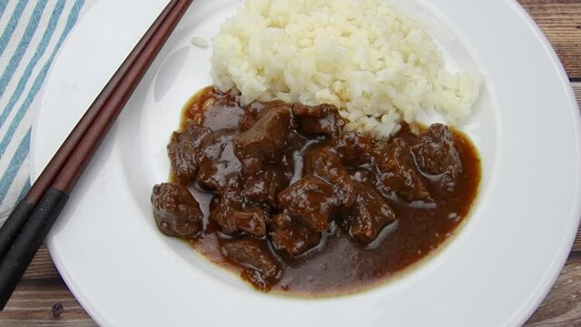 boeuf sauce aux oignons et riz dans une assiette